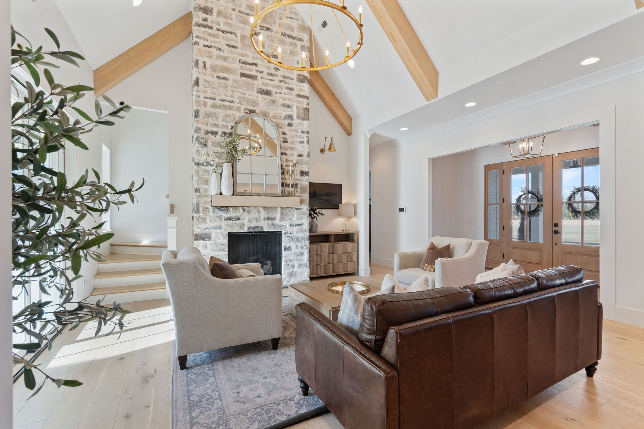 Living room with a stone fireplace and exposed timber beams
