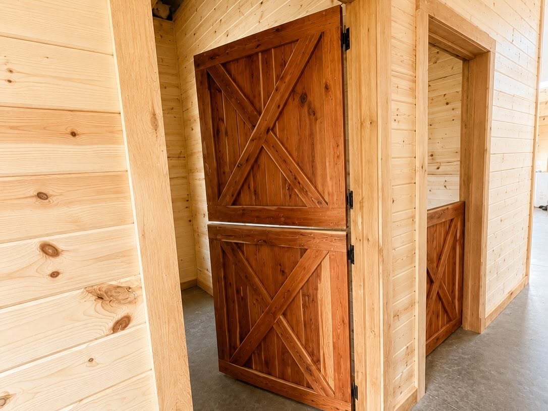 Warm wood stable doors with black metal hinges